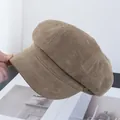 Gedetailleerd zicht op bruine suède newsboy pet met vintage knoop en zachte textuur - Khaki