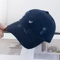 Détail macro d'une casquette vintage bleu marine avec broderie W rose et bords usés - Réglable / Bleu marine