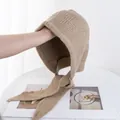 Detalle de pasamontañas de punto camel con lazos largos y textura acanalada suave - Caqui