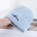 Détail de la broderie teckel sur bonnet en maille bleu clair avec texture côtelée douce - Rose bonbon