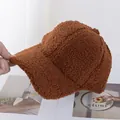 Dettaglio del cappello da baseball sherpa marrone con una spessa trama morbida in peluche - Regolabile / Caramello