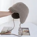 Detaillierte Strickstruktur einer dunkelbraunen Fliegermütze mit Ohrenklappen und Bändern - M (56-58cm) / Mokka