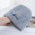 Close-up of grey knit beanie featuring a detailed dachshund embroidery with cursive text - Light Gray