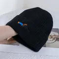 Close-up of cute dachshund dog embroidery on a black ribbed knit beanie hat - Black