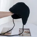 Nahaufnahme der schwarzen Strickmütze mit Ohrenklappen und langen Bindebändern - M (56-58cm) / Schwarz