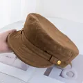 Detailed view of a brown suede baker boy hat with decorative band and gold button - Adjustable / Camel