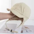 Detailed view of beige fleece-lined cycling hat with ear flaps and adjustable strap - Beige