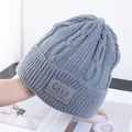 Detail van grijze gebreide muts met leren patch en dikke, warme kabelstructuur - Eén Maat(Elastisch) / Lichtgrijs