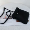 Close-up of black suede crossbody bag with fluffy faux shearling trim and gold button - 22*25 / Black