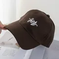 Detail of dark brown cotton baseball cap featuring white artistic letter embroidery - Coffee