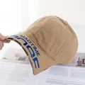 Detailaufnahme der Khaki-Baumwollkappe mit Used-Look und blauer MADTIME-Stickerei - Verstellbar / Dunkelbeige