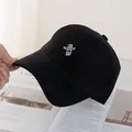 Close-up of embroidered astronaut on a black cotton baseball cap with wide brim - Black