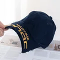 Détail de la casquette de baseball en denim bleu foncé avec broderie jaune et visière usée - Réglable / Bleu marine
