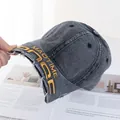 Détail de la casquette de baseball en denim gris délavé avec broderie et bords effilochés - Réglable / Gris & Noir