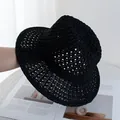 Detail of hand-held black hollow crochet Panama straw hat for sun protection and summer beach use - Adjustable / Black