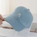 Detailed view of light blue baseball cap featuring a white astronaut embroidery - Blue