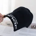 Gros plan du bord usé avec bords effilochés et broderie blanche sur une casquette noire - Réglable / Noir pur