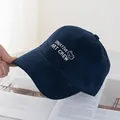Close-up of navy blue cotton baseball cap with white bear embroidery on an open magazine - Regular (54-59CM) / Navy Blue