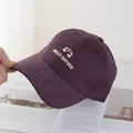 Dettaglio del ricamo bianco e del tessuto in twill di cotone su un cappello viola - Taglia Regolare / Viola
