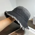 Detailed macro view showing the frayed edge texture of a dark grey washed denim bucket hat - Adjustable / Black