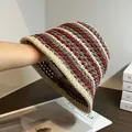 Dettaglio ravvicinato del cappello a secchiello in paglia lavorato a maglia con trama a righe - M (56-58cm) / Caffè e Bordo Beige