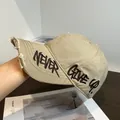 Detalle de gorra de béisbol de lona caqui desgastada con bordado 'NEVER GIVE UP' - Ajustable / Caqui