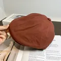 Gros plan détaillé de la casquette gavroche terracotta avec bouton et coutures texturées - Réglable / Rouge Brique