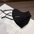 Detail of black UPF50+ ice silk sunmask with adjustable straps and logo on a book - Black