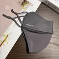 Detail of grey UPF50+ breathable sun mask with adjustable ear loops on wood surface - Dark Gray