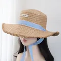 Détail d'un chapeau de paille avec ruban à carreaux bleu et bords effilochés élégants - M (56-58cm) / Kaki