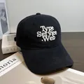 Primer plano del bordado blanco en gorra de algodón negro con textura de sarga - Ajustable / Negro