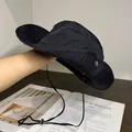 Dettaglio di un cappello da sole nero con trama del tessuto leggera e cordino antivento - L (59-63cm) / Nero