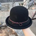 Close-up of black knitted sun hat with brown suede bow and breathable texture - M (56-58cm) / Black