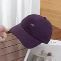 Detailweergave van de donkerpaarse katoenen baseballcap met wit plus-borduurwerk - Verstelbaar / Paars