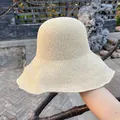 Macro detail of fine knit beige sun hat showing hand-woven texture and wavy brim - Large Brim Style / Beige