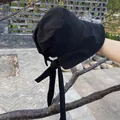 Detail showing the ribbon bow and texture of the lightweight black sun hat with wide brim - M (56-58cm) / Black