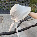 Detail of light beige sun hat showing the elegant bow and long ribbon on breathable fabric - M (56-58cm) / Beige