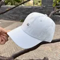 Close-up of minimalist cat embroidery on a light blue cotton baseball cap in outdoor light - Adjustable / Blue
