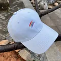 Detalle de gorra de béisbol de algodón azul claro con bordado de arcoíris en rama - Ajustable / Azul