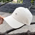 Detail of a beige cotton baseball cap with a minimalist black cat head embroidery - Adjustable / Beige