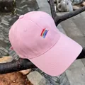 Detalle del bordado de arcoíris y la textura de algodón rosa en una gorra de béisbol - Ajustable / Rosa
