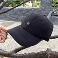 Detailed close-up of cute white cat embroidery on a black cotton baseball cap - Adjustable / Black