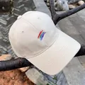 Detalle de gorra de algodón beige con bordado de arcoíris sobre una rama de árbol - Ajustable / Beige