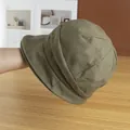 Detail of olive green canvas bucket hat showing multi-panel stitching and retro texture - Adjustable / Camel