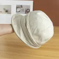 Detailed close-up of beige linen bucket hat showing natural fiber texture and brim folds - Adjustable / Beige