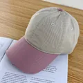 Close-up of contrast color cotton baseball cap on a book with fine stitching details - Adjustable / Beige and Pink Brim