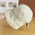 Detail of adjustable black drawstring toggle on a beige quick-dry sun hat fabric - Adjustable / Beige