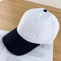 Detail of white and black contrast baseball cap with breathable eyelets on wooden desk - Adjustable / White and Black Brim