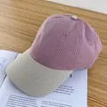 Detail view of a contrast-color baseball cap in lilac canvas with a beige brim on a book - Adjustable / Pink and Beige Brim
