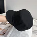 Close-up of black knitted retro equestrian cap with fine textured material on magazine - Adjustable / Black